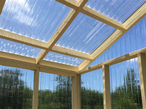 the inside of a building with glass walls and wood beams on it's sides