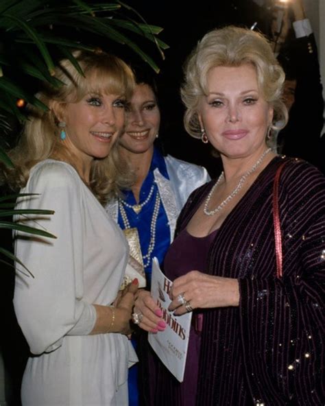 three women standing next to each other at an event