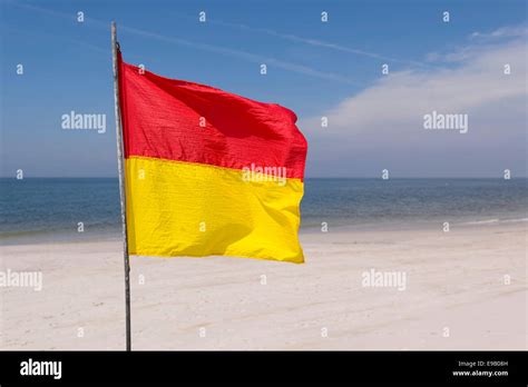 A red-yellow flag waves on the beach, near Kampen, Sylt, Schleswig ...