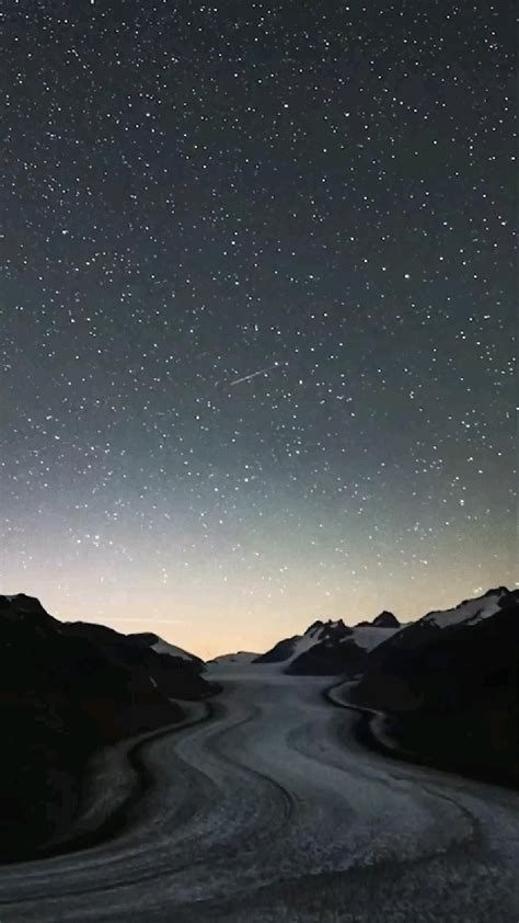 the night sky is filled with stars above mountains