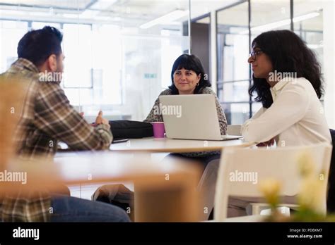 Business people with laptop talking in office meeting Stock Photo - Alamy