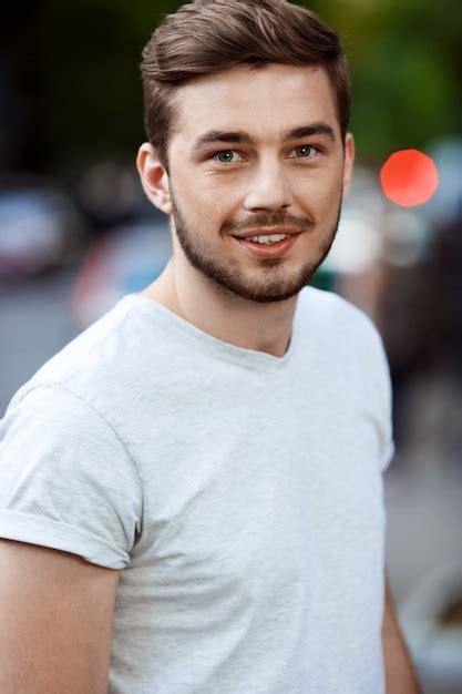 Free Photo | Close up portrait of handsome smiling young man in white t-shirt on blurry outdoor ...