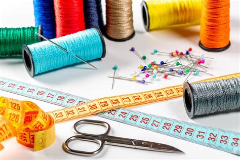 Colored sewing thread and bobbin with measuring tape, scissors and ...