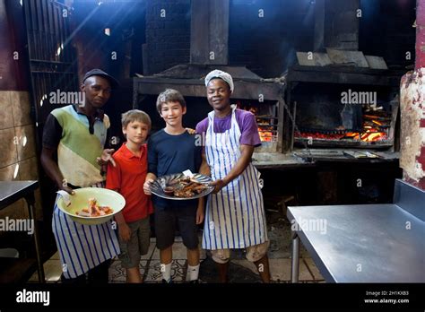 Tween boys cooking with local South Africans at Mzoli's in Gugulethu ...