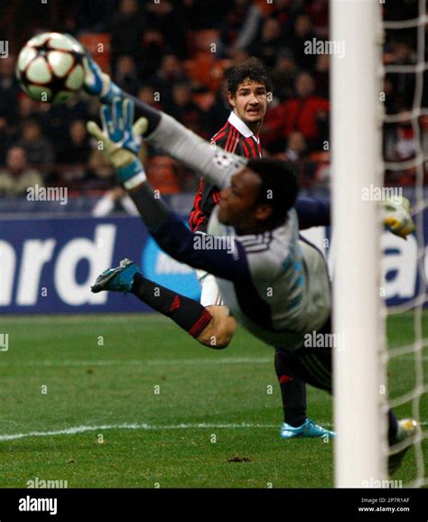 Marseille goalkeeper Steve Mandanda saves a shot by AC Milan Brazilian forward Pato, background ...