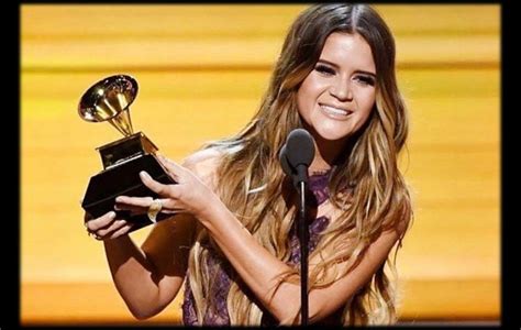 a woman holding an award in front of a microphone