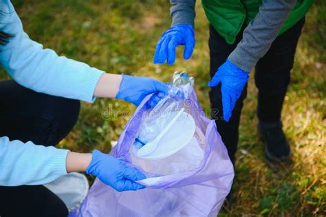 Smiling Boy Picking Up Trash in the Park with His Mother. Volunteer ...