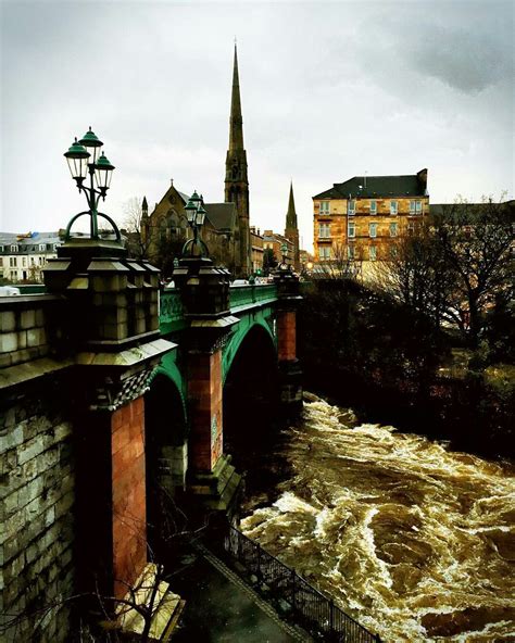 a bridge that has some water coming out of it and buildings on the ...