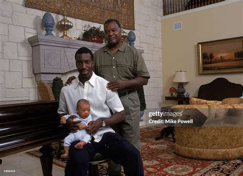 Michael Johnson poses with his son Sebastian on his knee and his ...