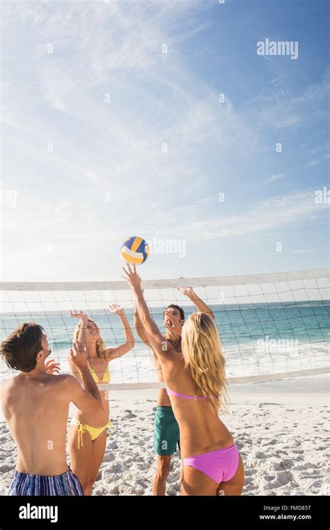 Happy friends playing beach volleyball Stock Photo - Alamy