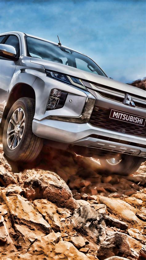 a silver truck driving on rocks in the desert