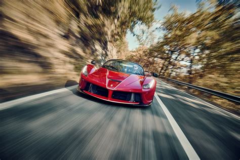 a red sports car driving down the road