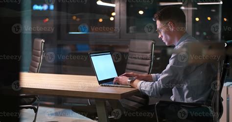 man working on laptop in dark office 11321010 Stock Photo at Vecteezy