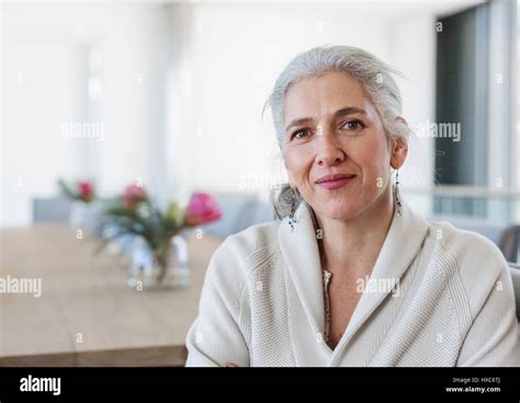 Portrait mature woman sitting at dining table Stock Photo - Alamy