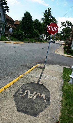 a stop sign on the corner of a street with graffiti painted on it's sidewalk