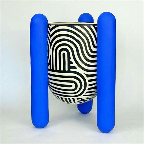 a black and white vase with blue handles