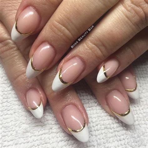 french manicure with gold details, on two pale hands, with medium to short pointy nails Acrylic ...