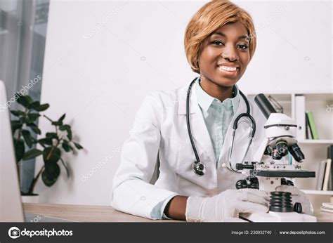 Cheerful Female African American Scientist Holding Microscope ...