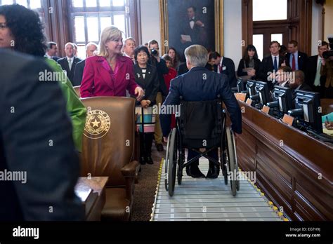 Texas Gov. Greg Abbott rolls his wheelchair down ramp from dais in ...