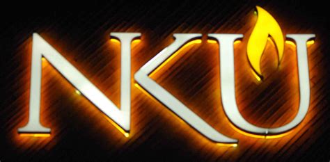 the letter k u is lit up against a black background with orange and yellow lights