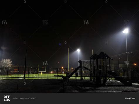 Empty school football field and playground at night stock photo - OFFSET