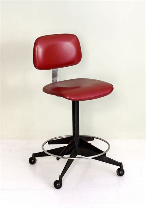 Premium Photo | Retro office chair with red seat and wheels