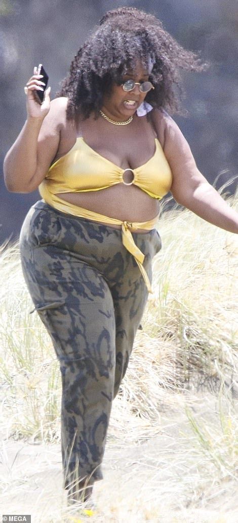 Lizzo flies the flag for body positivity as she hits the beach in gold ...