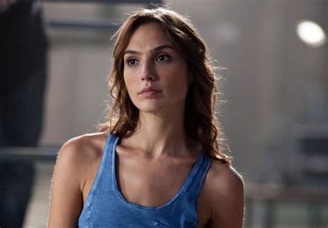 a woman wearing a blue tank top looking at the camera with an intense look on her face