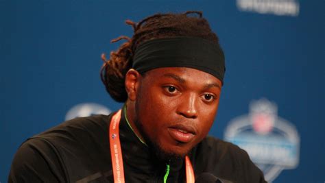 a man with dreadlocks and a headband on sitting in front of a microphone