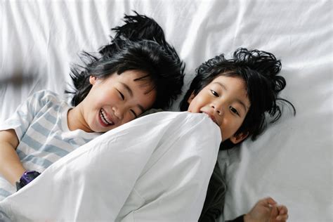 Kids Lying on White Bed · Free Stock Photo