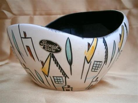 a white bowl with black and yellow designs on the bottom is sitting on ...