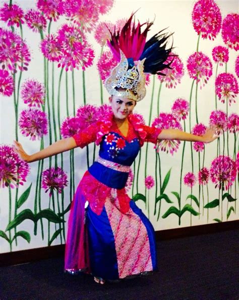 a woman in a colorful dress and headdress dancing