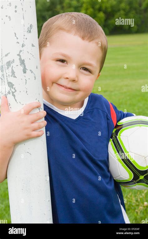 Young soccer player standing beside goal post Stock Photo - Alamy