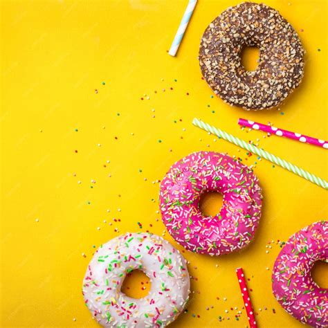 Premium Photo | Colorful donuts on yellow background