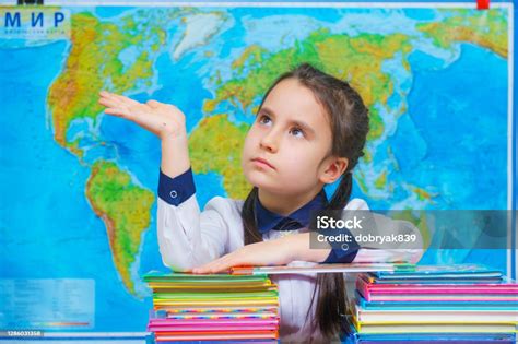Portrait Of A Smart Cute Girl Hugging A Lot Of Books On The Background Of The World Map Stock ...