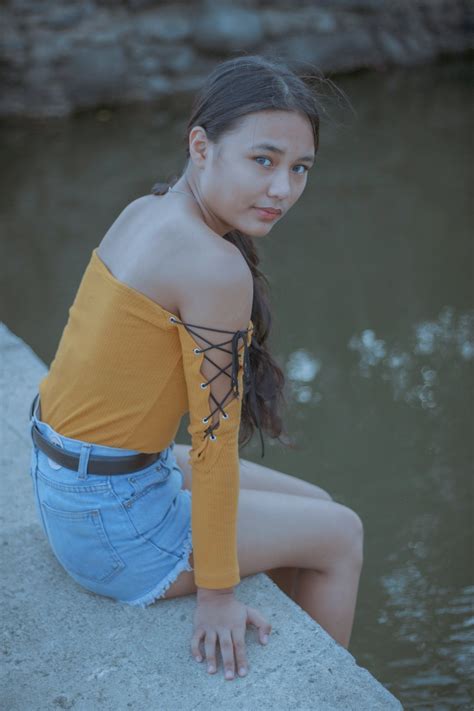 Teen girl in denim skirt resting near river · Free Stock Photo