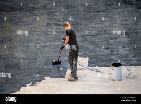 Construction site, application of a bituminous coating on a concrete ...