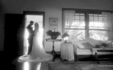 a bride and groom standing in front of a window at the end of their wedding day
