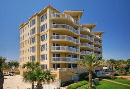 an apartment building with balconies and palm trees