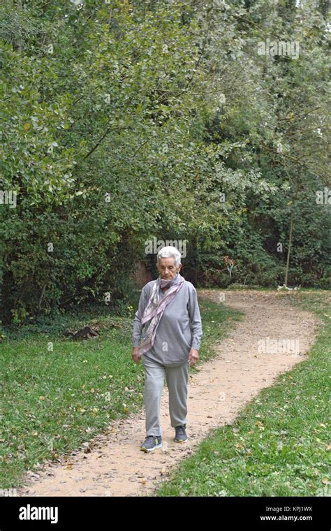 old woman walking in a park Stock Photo - Alamy