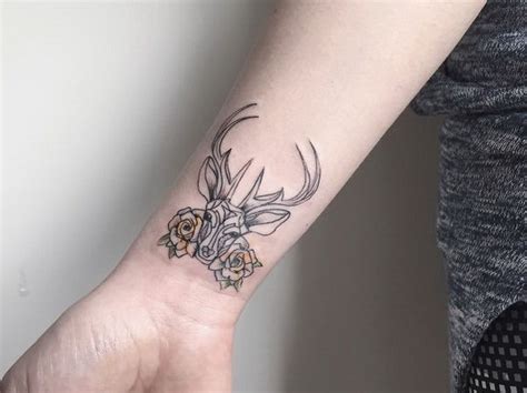 Black ink tiny wrist tattoo of deer with flowers - Tattooimages.biz