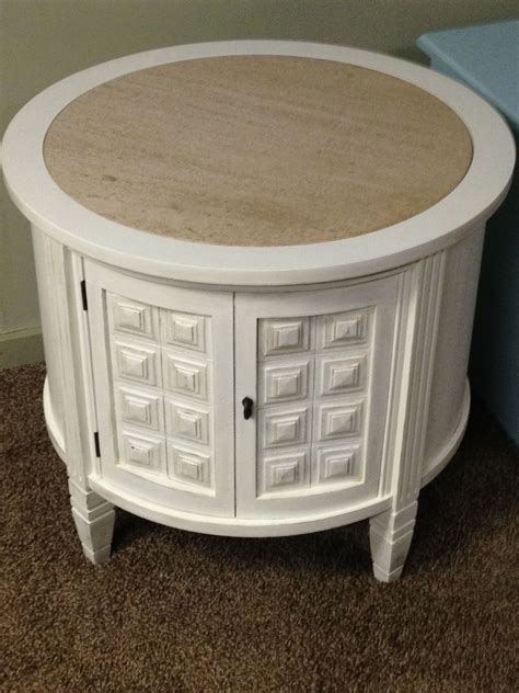 White distressed round end table with marble top.