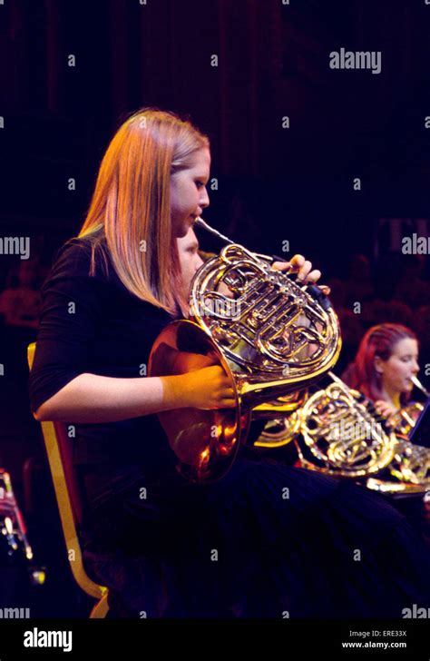 Female French horn player playing in a youth symphony orchestra at one ...