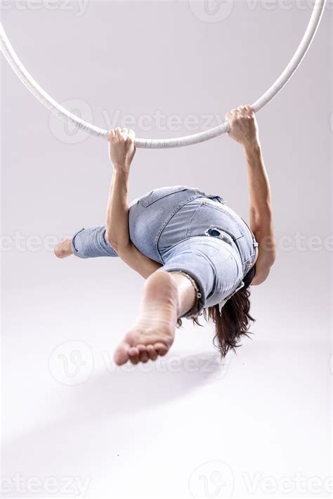 A female Aerial hoop gymnast performing exercises on an Aerial hoop ...