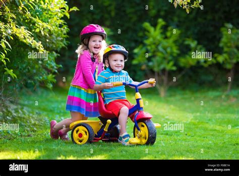 Kids riding bikes in a park. Children enjoy bike ride in the garden Stock Photo: 86304326 - Alamy