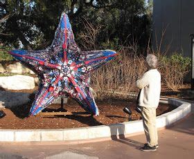 a man standing in front of a star sculpture