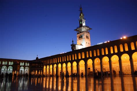 photo of orange lighted concrete building with people standing inside, damascus, umayyad mosque ...