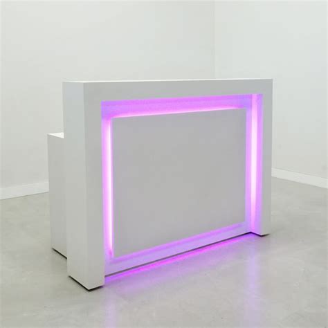 a white counter with purple lights on it's sides and the top half illuminated