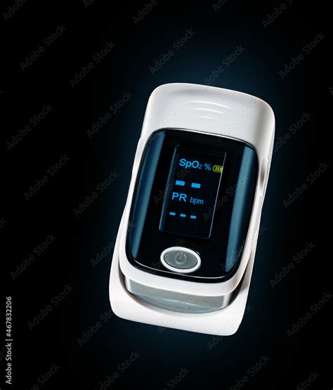 Pulse oximeter used to measure heart rate and oxygen level on a black ...