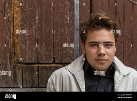 Young Caucasian male sitting on a vintage industrial loading dock smirking Stock Photo - Alamy